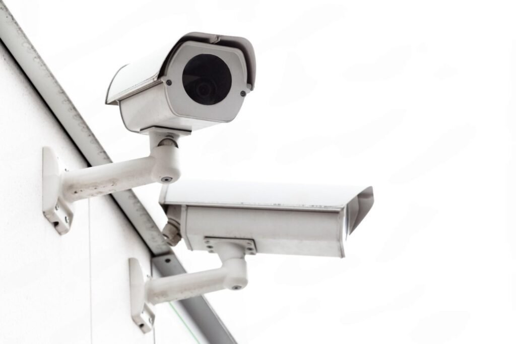 Two heavy-duty white outdoor bullet security cameras mounted securely to a building's exterior, representing the robust commercial hardware required when evaluating CCTV Monitoring Costs in Pakistan for a reliable cctv monitoring service and comprehensive business video surveillance.