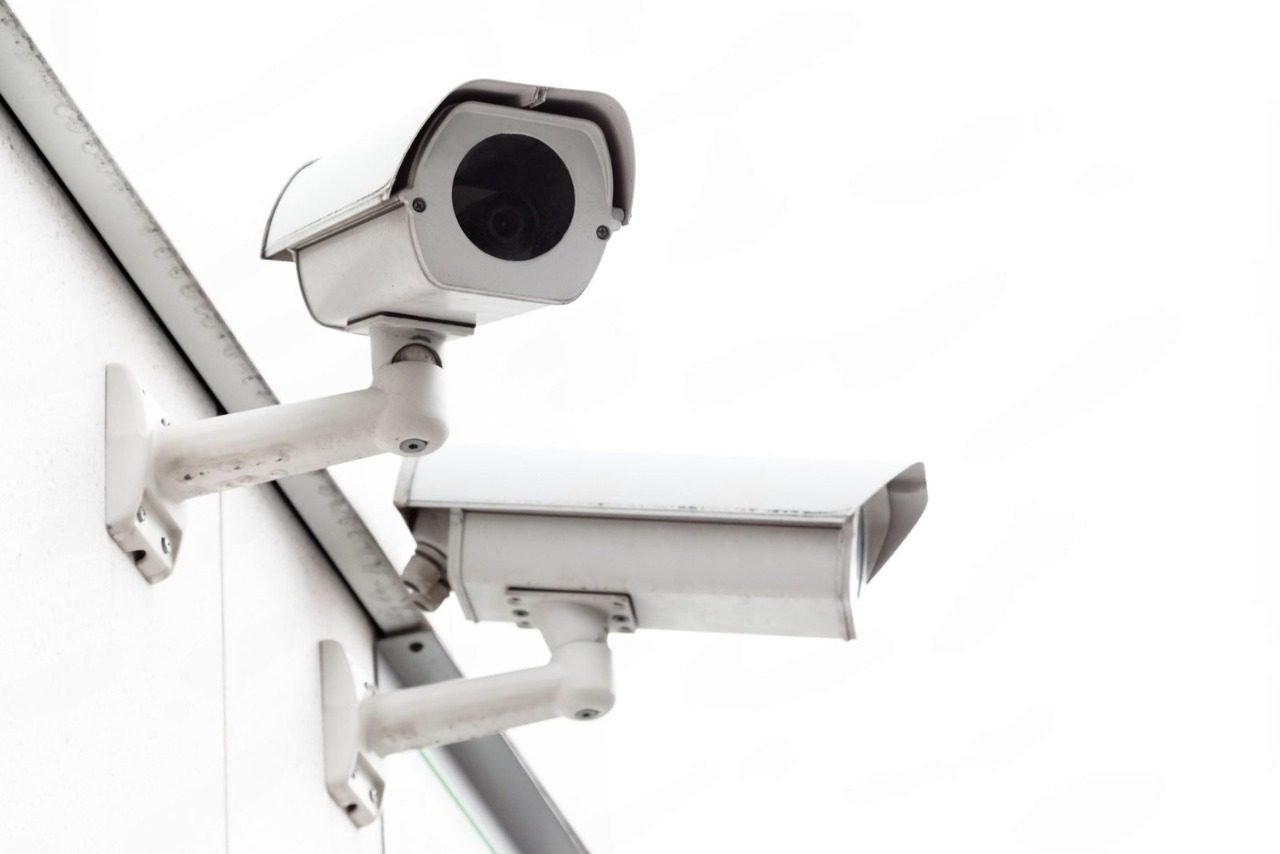 Two heavy-duty white outdoor bullet security cameras mounted securely to a building's exterior, representing the robust commercial hardware required when evaluating CCTV Monitoring Costs in Pakistan for a reliable cctv monitoring service and comprehensive business video surveillance.
